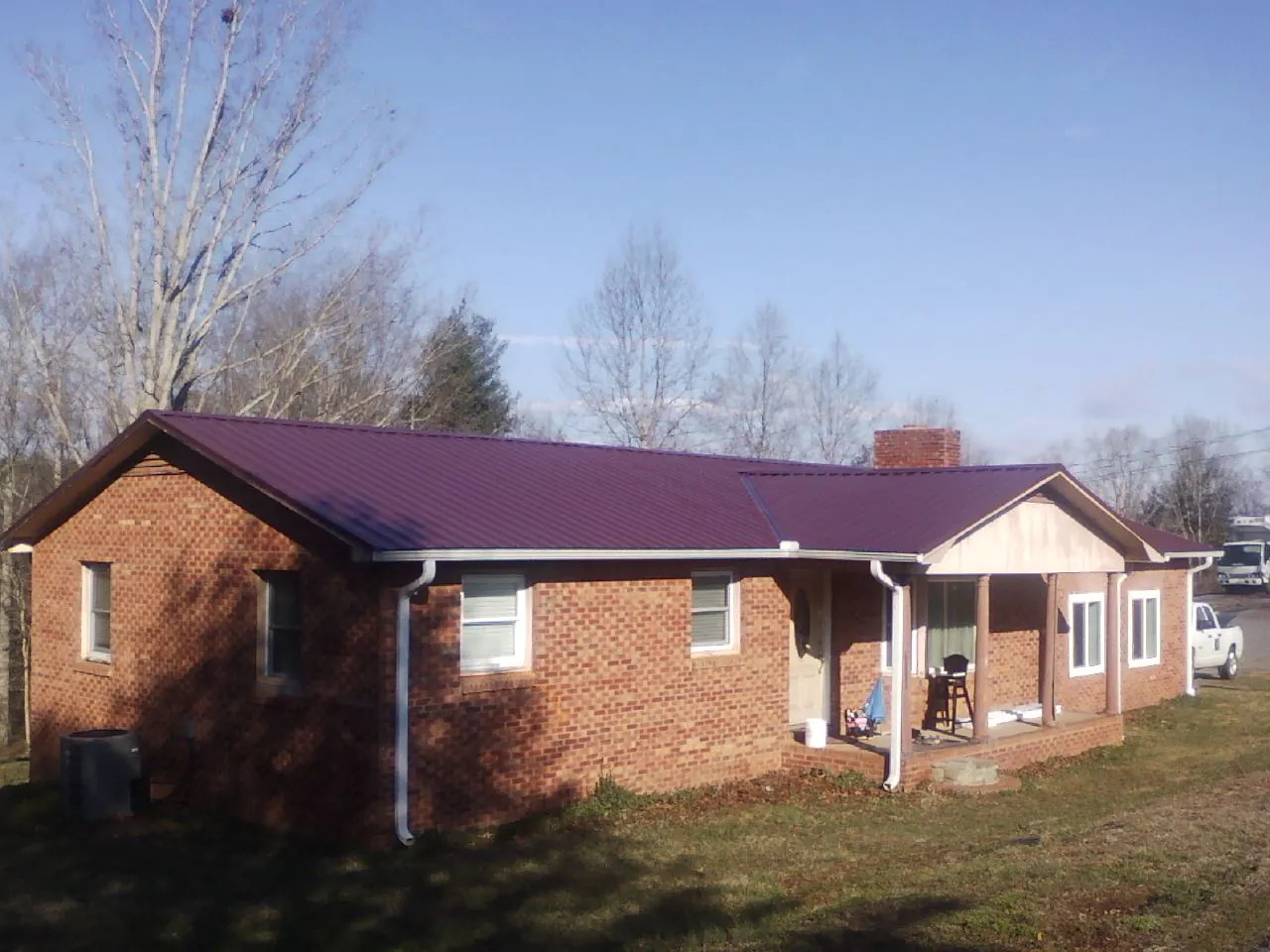 Burgundy metal roof on a brick ranch home with a new addition in Barneveld