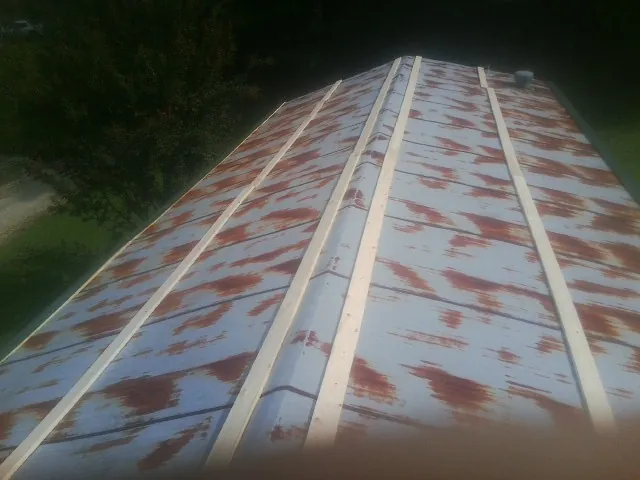 Rusted metal roof panels with new wood purlins before replacement — Storm Damage Roof Repair in Barneveld by Roofing Brothers